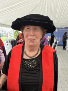 Dr Pam MacNeill in her PHD cap and gown on her graduation day